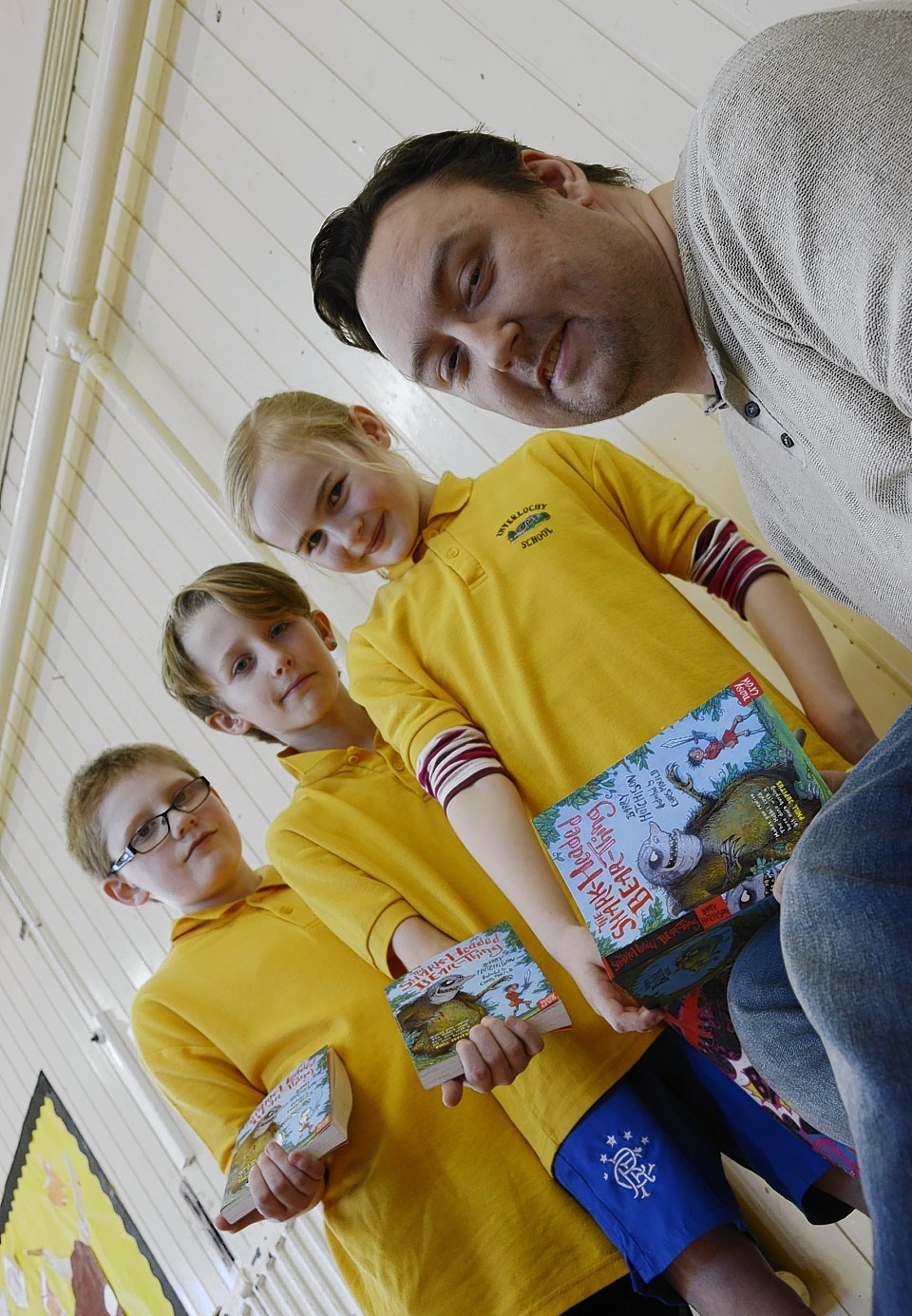 Children's author Barry Hutchison signs copies of his latest book The Shark Headed Bear Thing for Daniel Turner, Archie Bowman and Jasmyn Fox Gillies