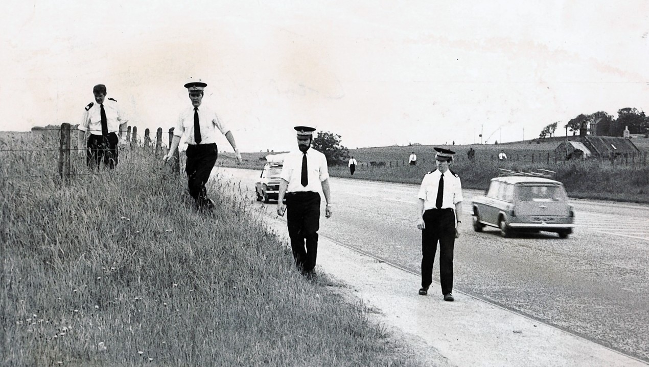 Police search the road from Aberdeen to Stonehaven looking for evidence to solve the murder.