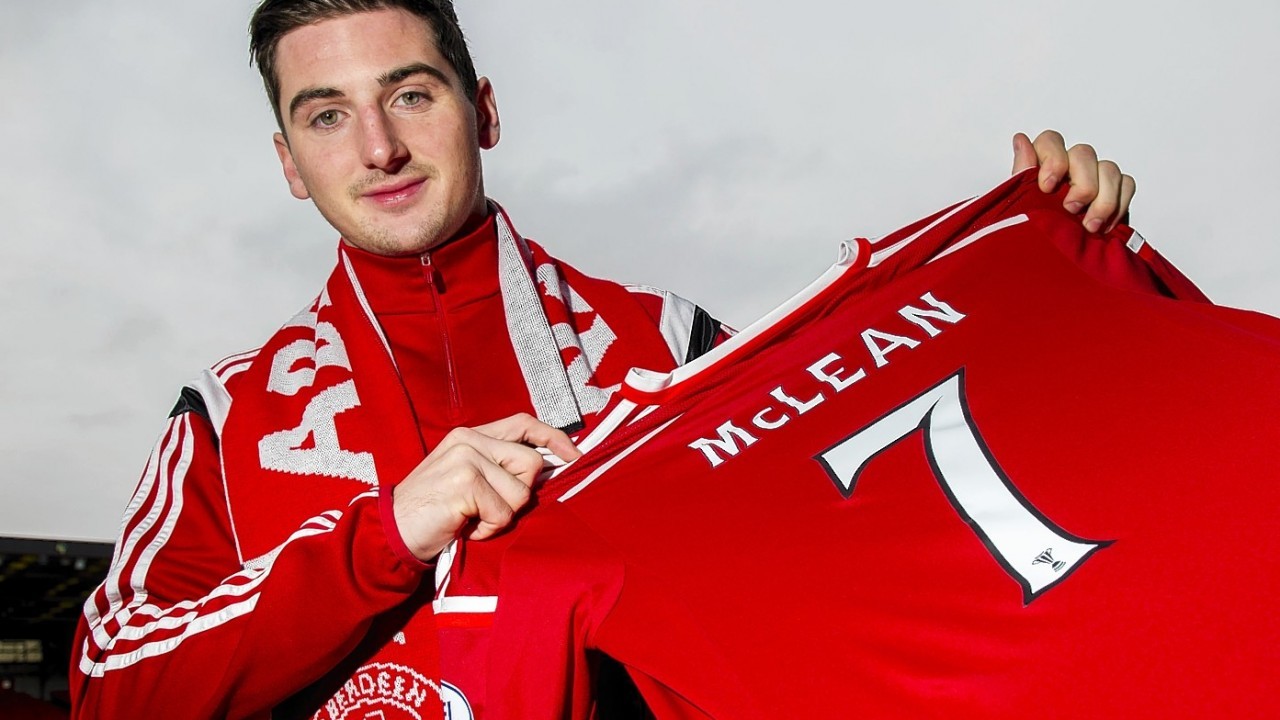 Kenny McLean proudly displays his Dons top