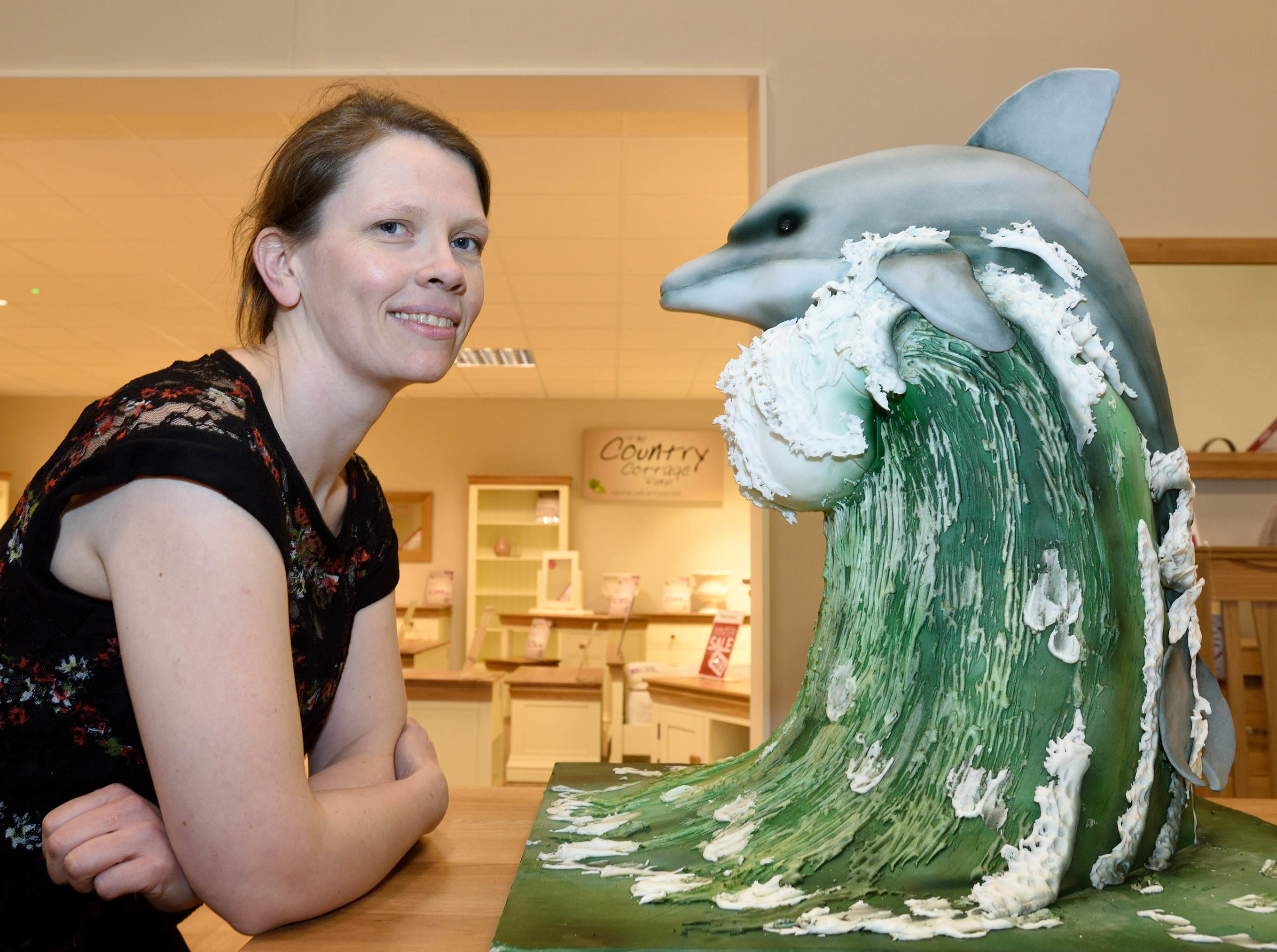 Janette MacPherson of Cake Craft and Cakebomb with her two foot high dolphin cake at the opening of Oakfurnitureland,