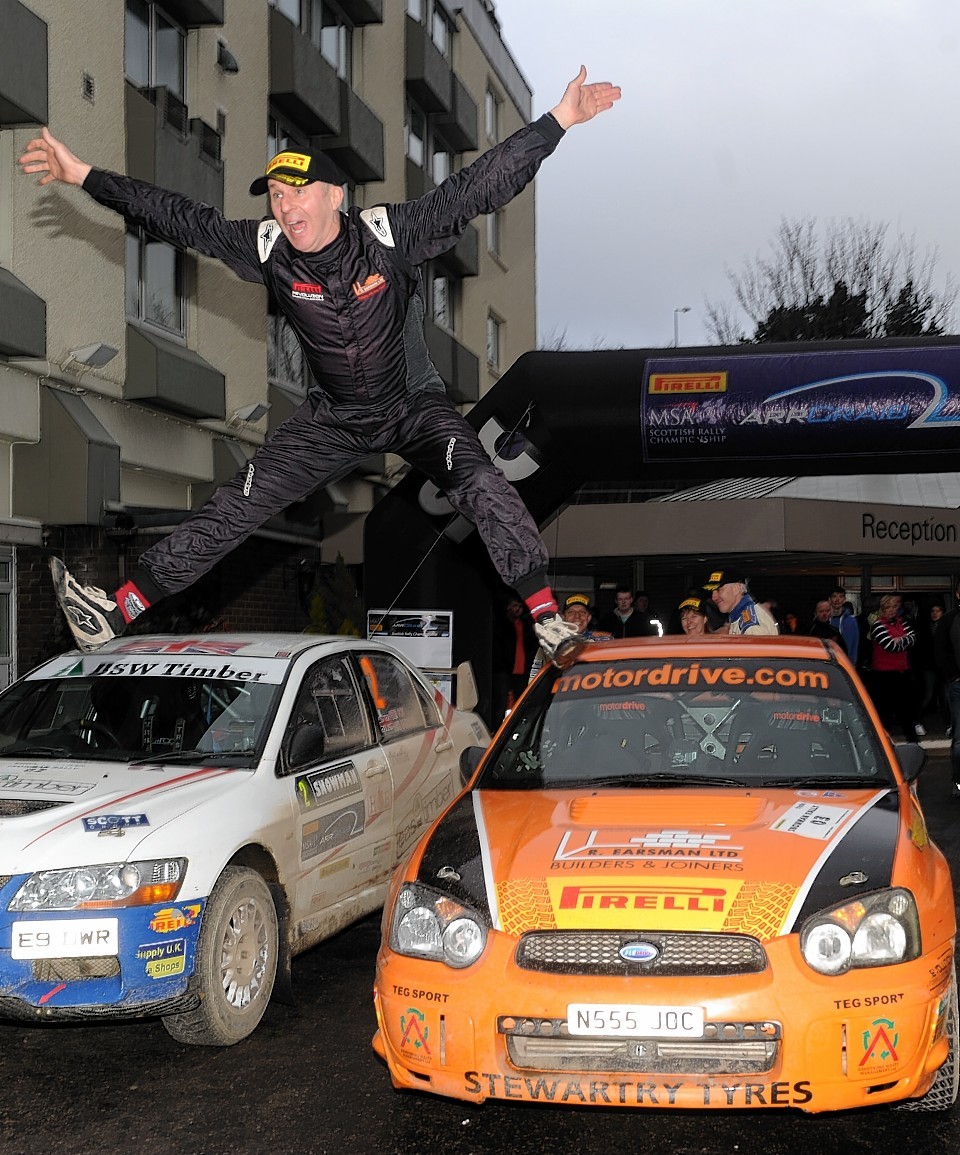 The winning driver, Jock Armstrong, leaps in celebration