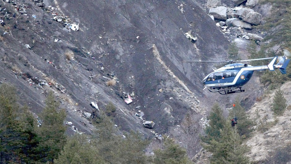 A rescue helicopter flies over the debris of the Germanwings jet on the mountainside near Seyne les Alpes (AP)