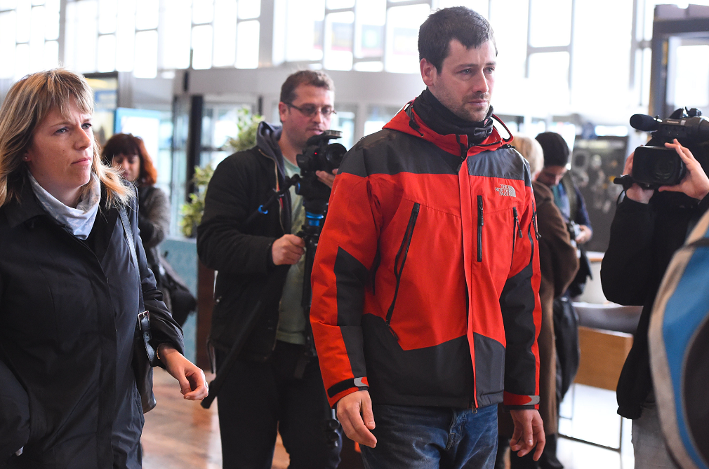 A man is guided through Dusseldorf airport with tears in his eyes to await news of his loved ones.