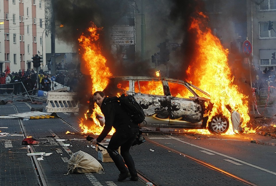 A police car burns after clashes between demonstrators and police