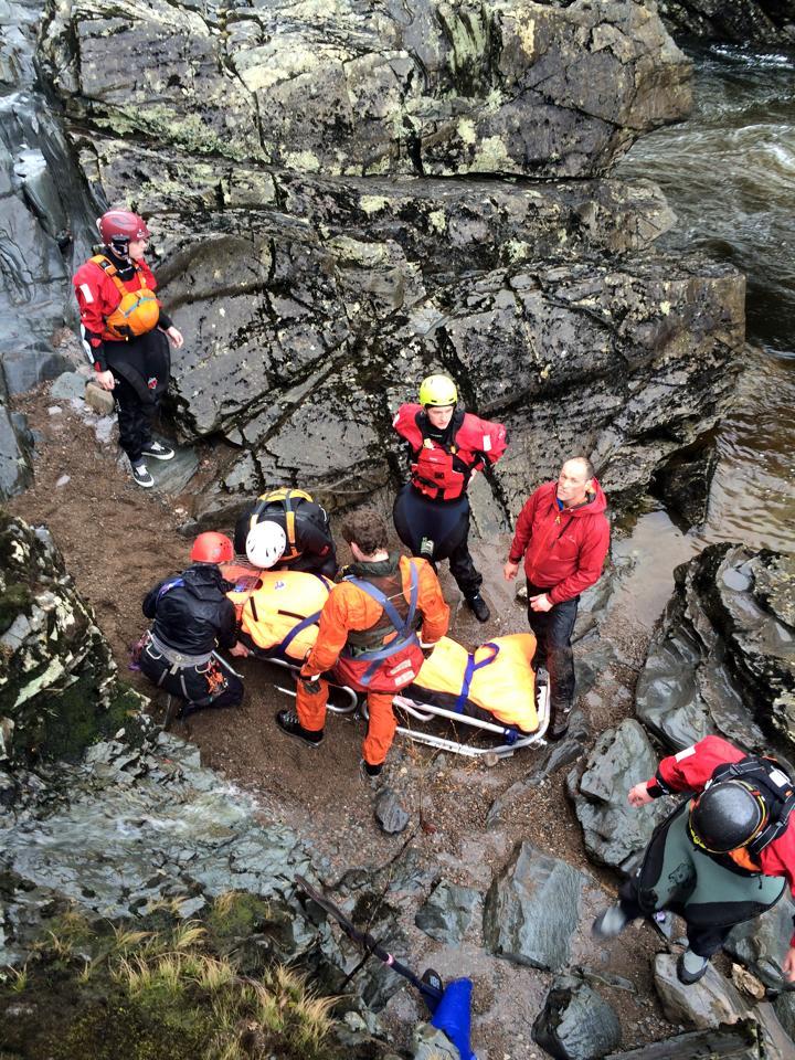Mountain rescuers secure the kayaker on a stretcher
