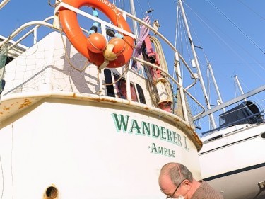 Fred Nason prepares his boat for the season in beautiful sunshine at Inverness Marina