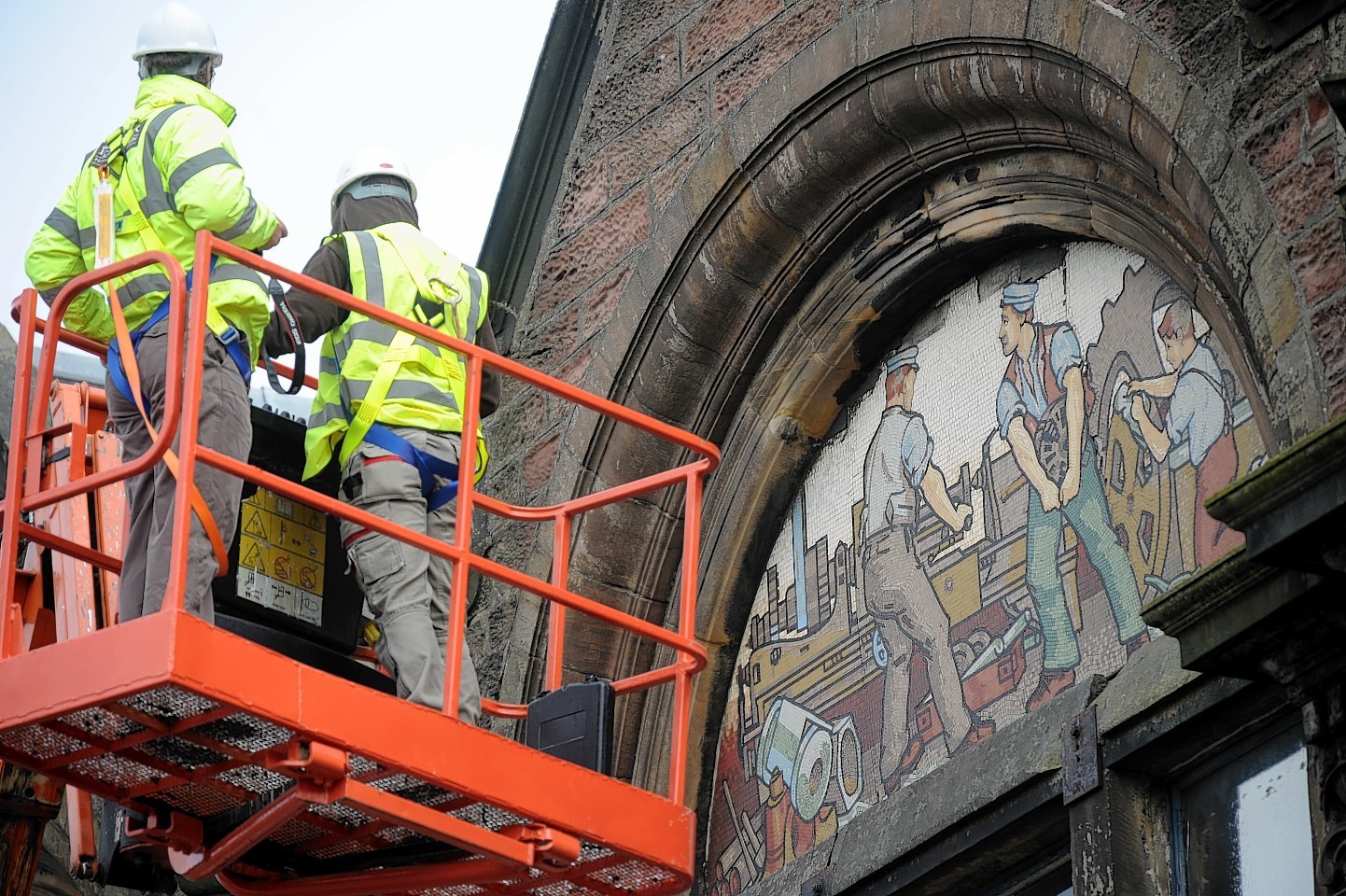 Experts examine the mosaics at the AI Welders building