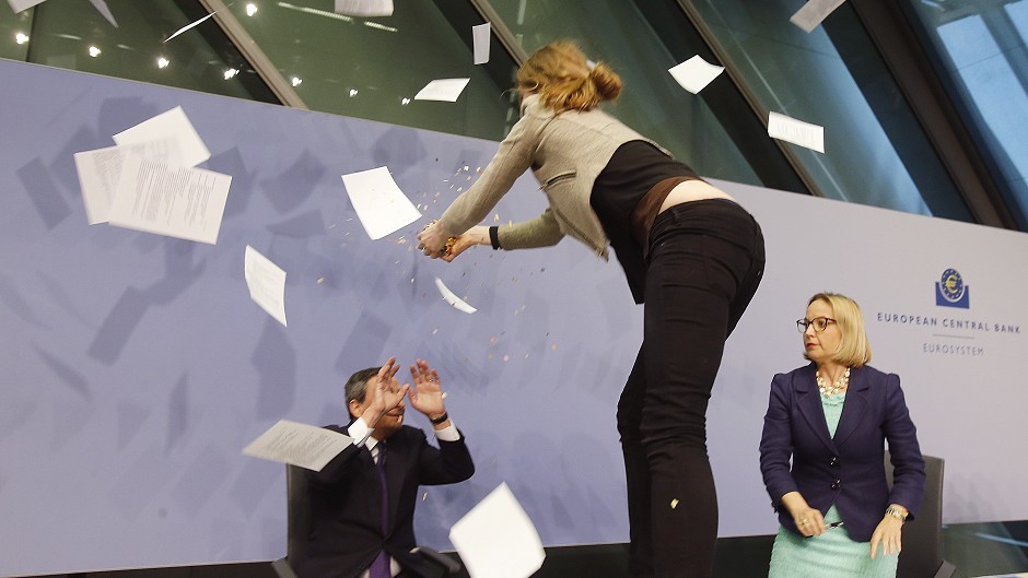 An activist throws paper at European Central Bank president Mario Draghi during a press conference (AP)