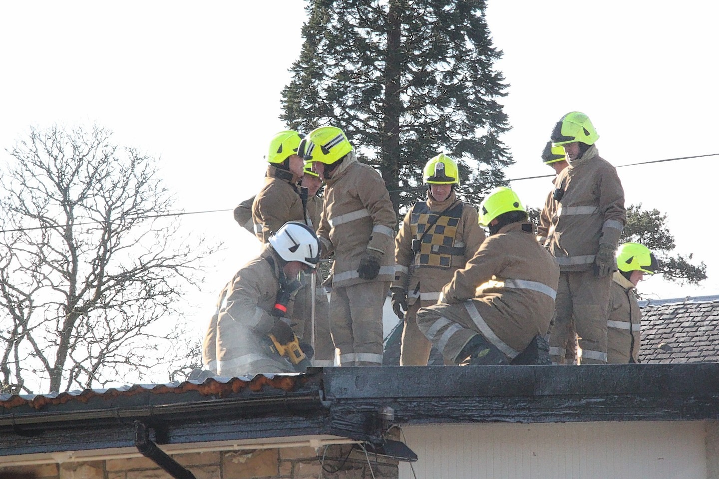 Firefighters work on the roof of the Spean Bridge Hotel after Tuesday's fire