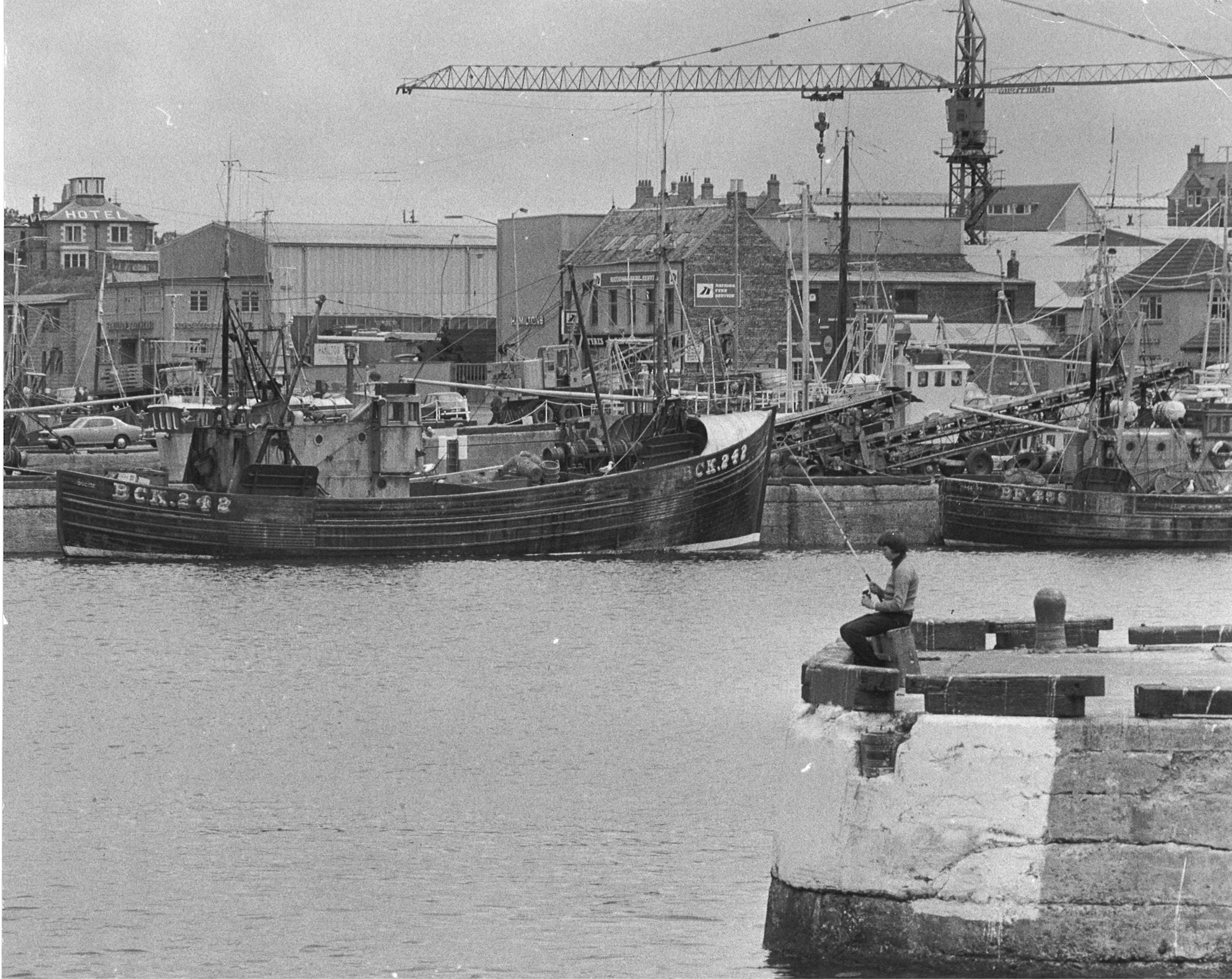 1974, quite scene at Cluny Harbour, as a lone fisherman sits on the edge of the pier hoping for a bite of the industry. 