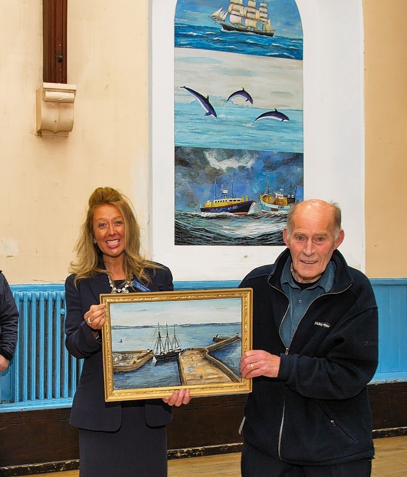 Nicola Thomson presents the painting to Neil Smith, chairman of the Community Hall.