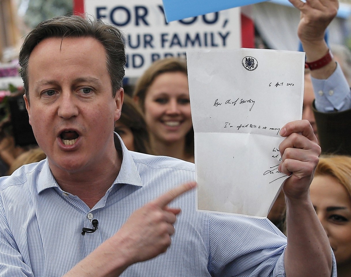 Prime Minister David Cameron shows the letter by a former Labour Treasury Minister Liam Byrne saying "there is no more money" as he speaks to supporters at Squires garden centre in Twickenham, London