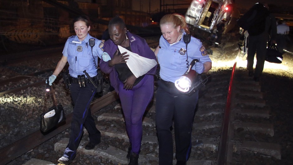 Emergency personnel help a passenger at the scene of the train crash in Philadelphia (AP) 