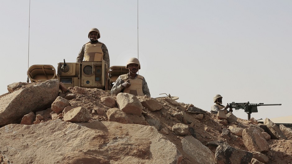 Saudi soldiers stand on top of armoured vehicles, on the border with Yemen at a military point in Najran.