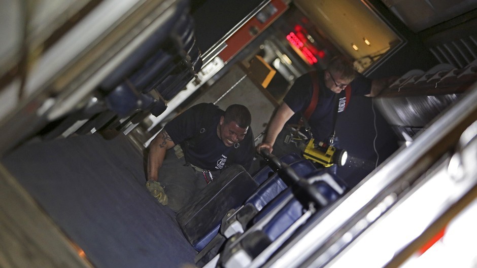 Rescue workers inside the derailed carriage (AP)