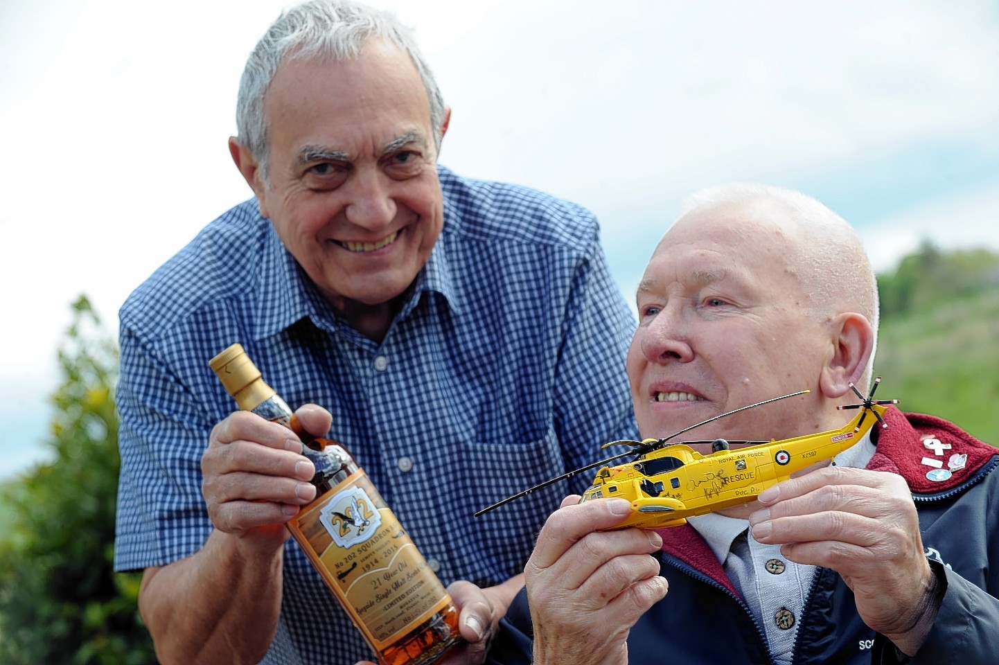 Rob Matthews with the Seaking model he's donating to Mrayvia to be auctioned and Bob Pountney with the bottle of 202 Squadron whisky, also to be auctioned. Picture by Gordon Lennox