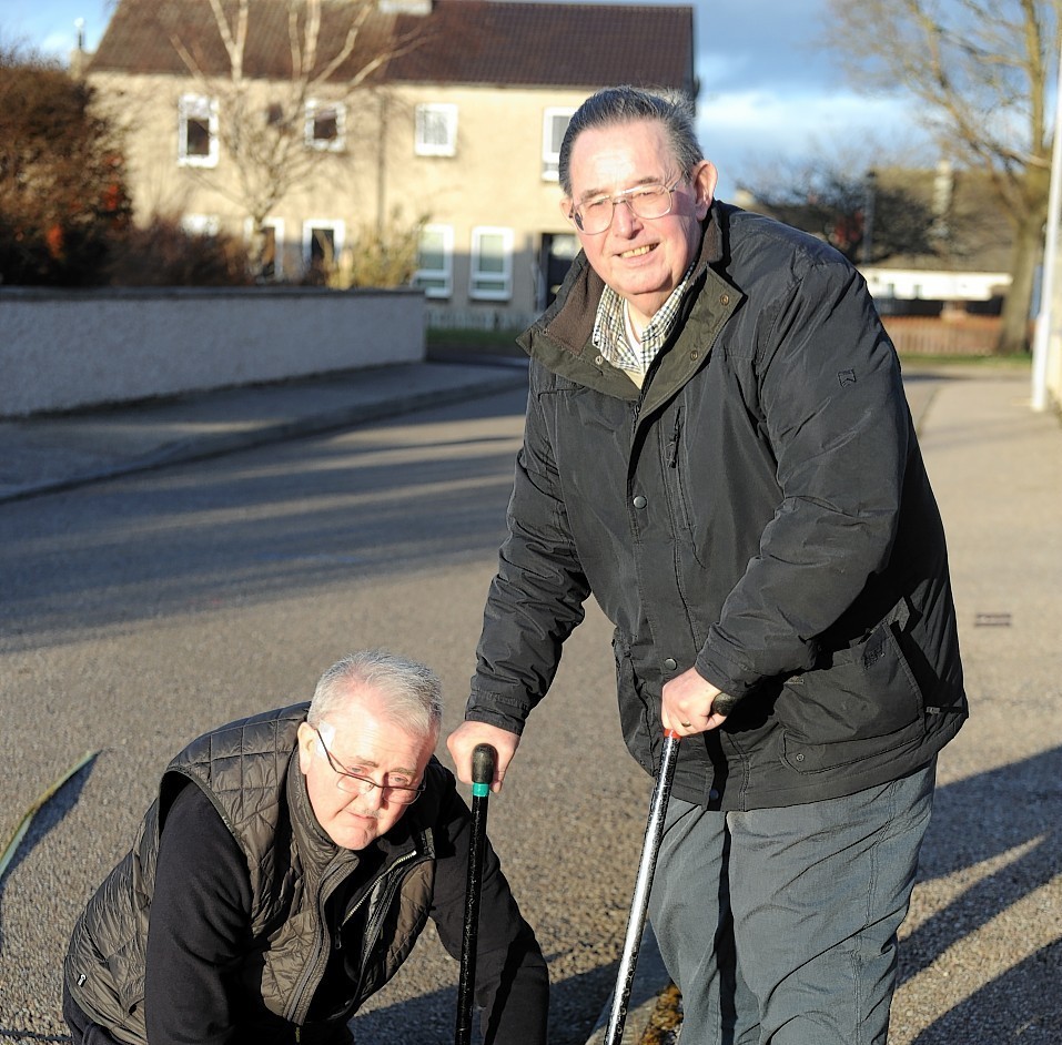 John Hamilton, left, and Robert Murdoch, right, measuring the road width in Halliman Way