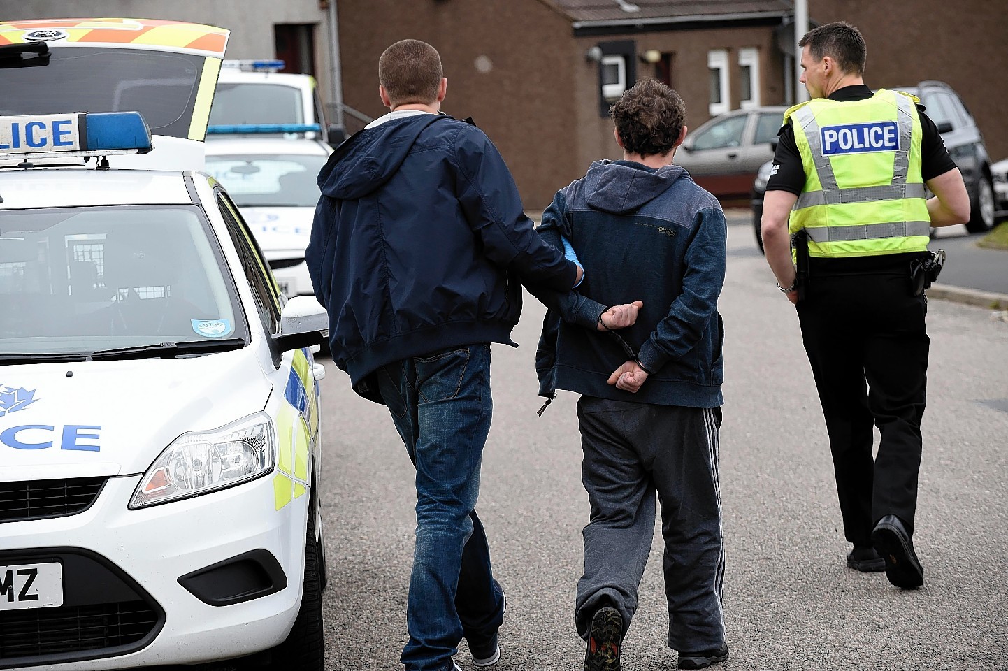 A man is taken away from Scalloway Park during the raids