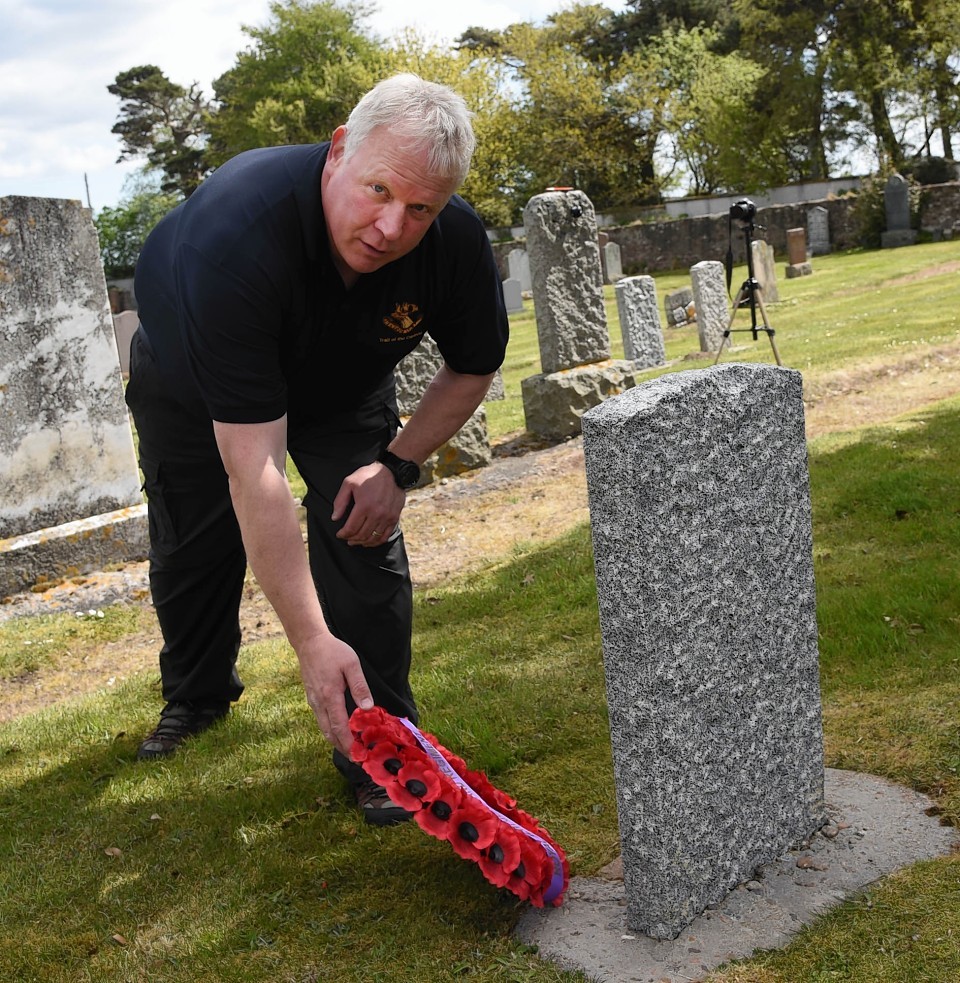 Major Michael Pretty lays the wreath at Private John Chaplin's grave in Ardersier