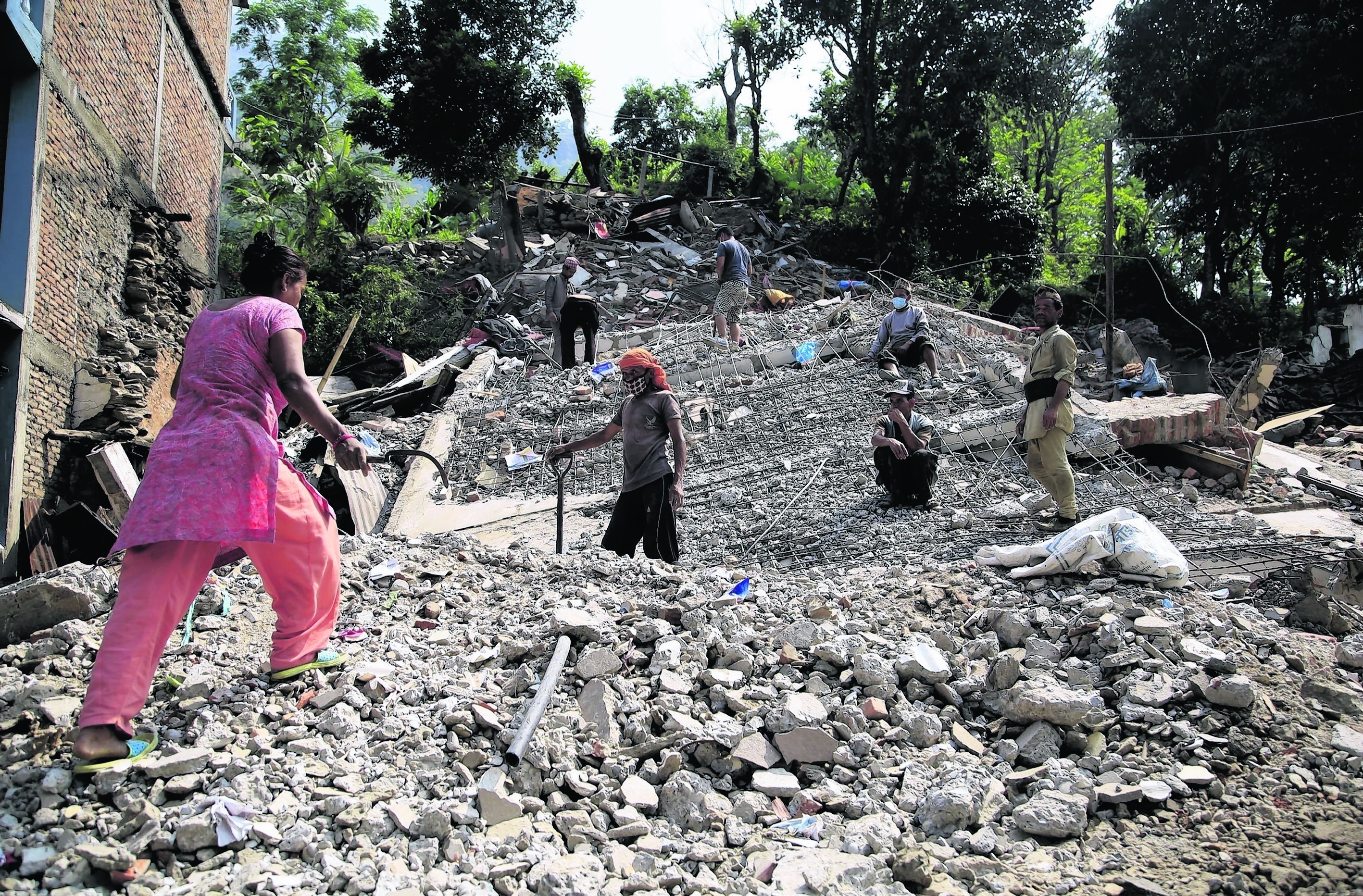 Nepali people collect usable belongings amid the debris of destroyed houses at Lamosangu village in Sindhupalchowk, Nepal after the 7.8-magnitude earthquake
