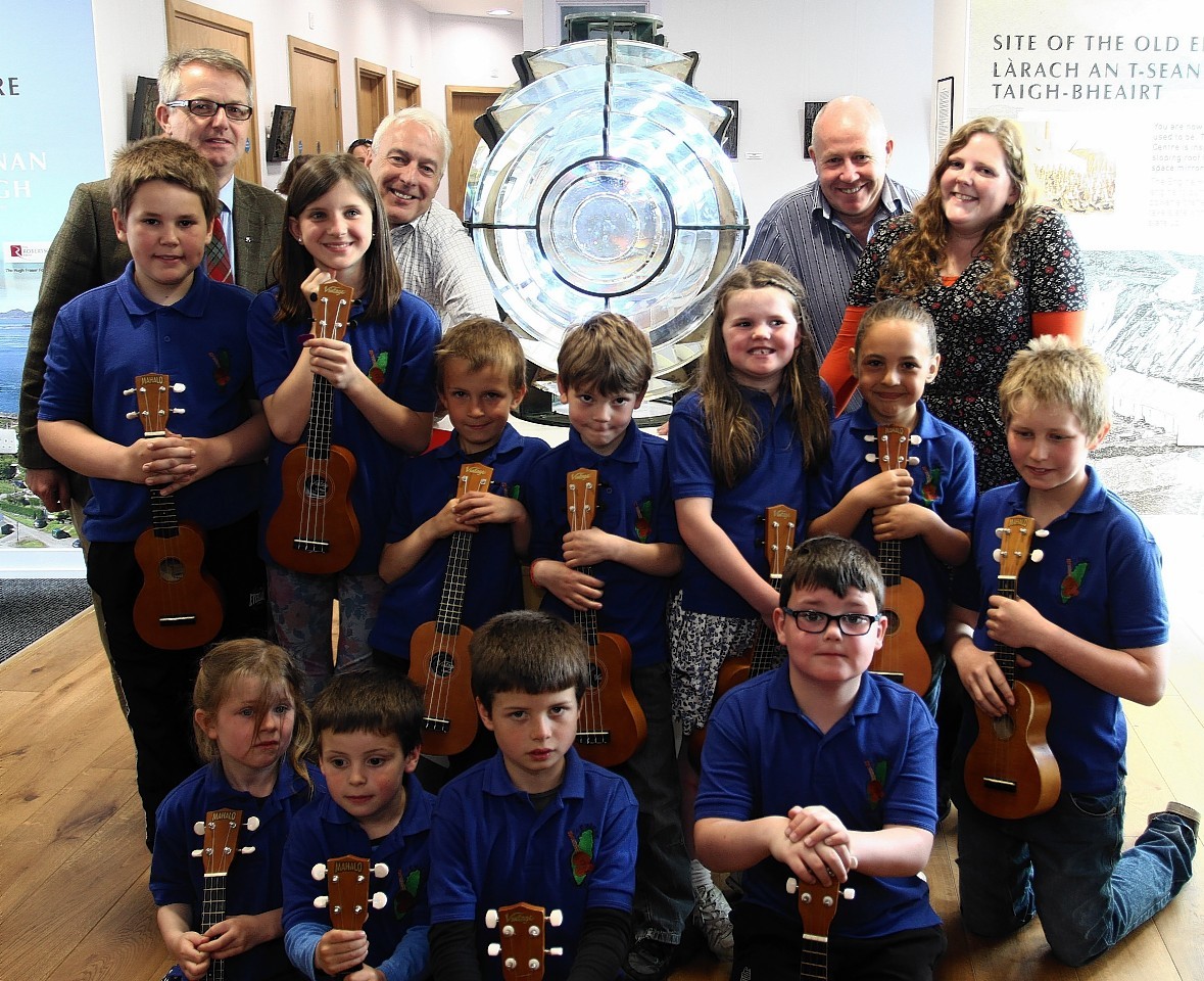 Brendan O'Hara MP for Argyll and Bute (left)  performs his first official task since he has been elected to parliament by helping the Trustees and Children of Luing Primary School unveil the Fladda Light