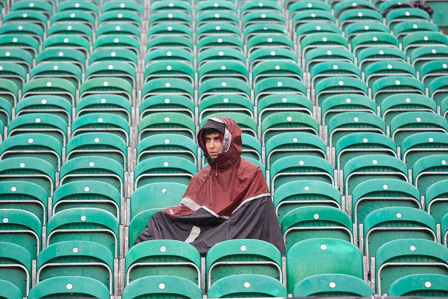 A usually packed stand is home to a damp fan during another downpour at Fort William.