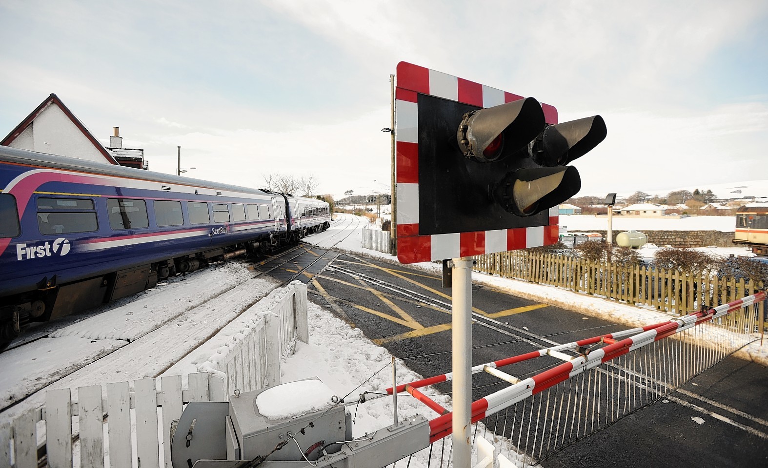 Insch Level Crossing has been closed. Picture shows the level crossing with a train passing through.