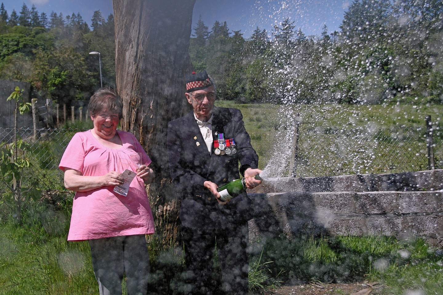 Betty and Geordie Rhodick crack open the champagne after winning on the lottery