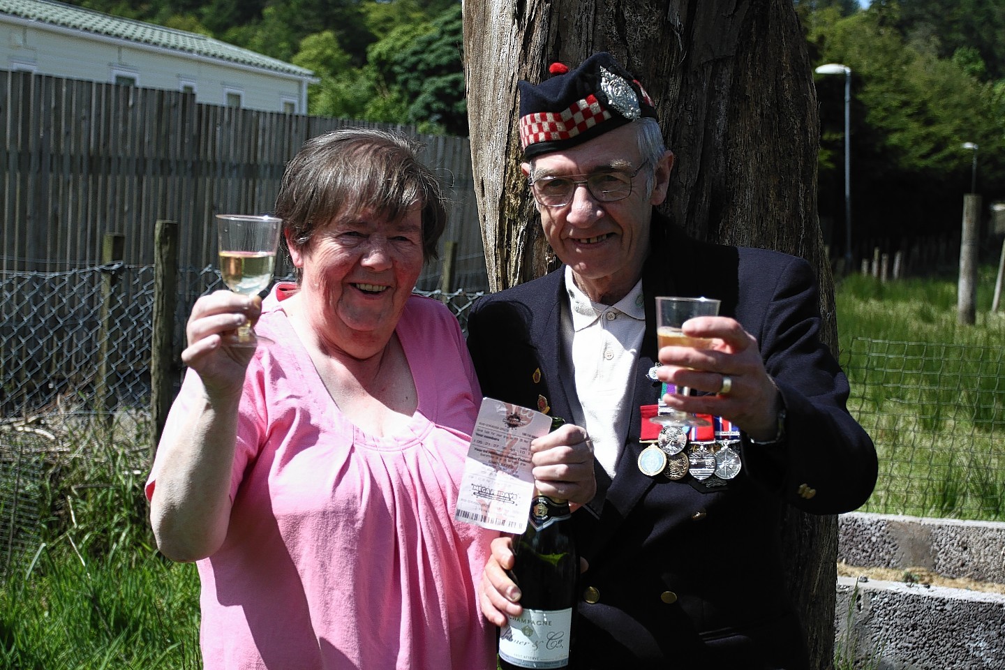Betty and Geordie Rhodick crack open the champagne after winning on the lottery