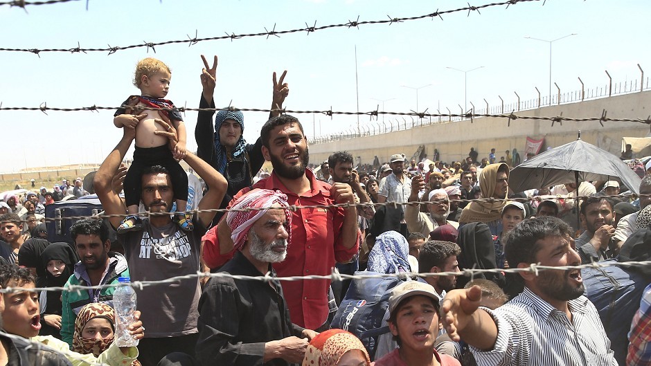 Syrian refugees gather at the Turkish border