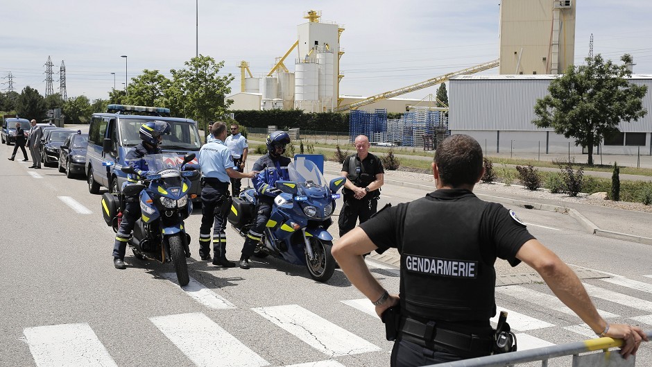 Police officers block the area where an attack took place in Saint-Quentin-Fallavier, south-east of Lyon, France (AP)