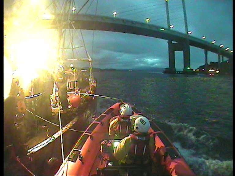 RNLI Kessock come under The Kessock Bridge with fishing vessel alongside