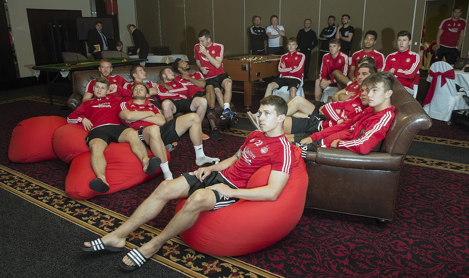 The Dons squad watch the draw unfold