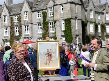 Balmoral housekeeper Sheena Stuart and expert Alastair Dickenson with a painting and a silver on bronze statue of Queen Victoria's piper William Ross.      