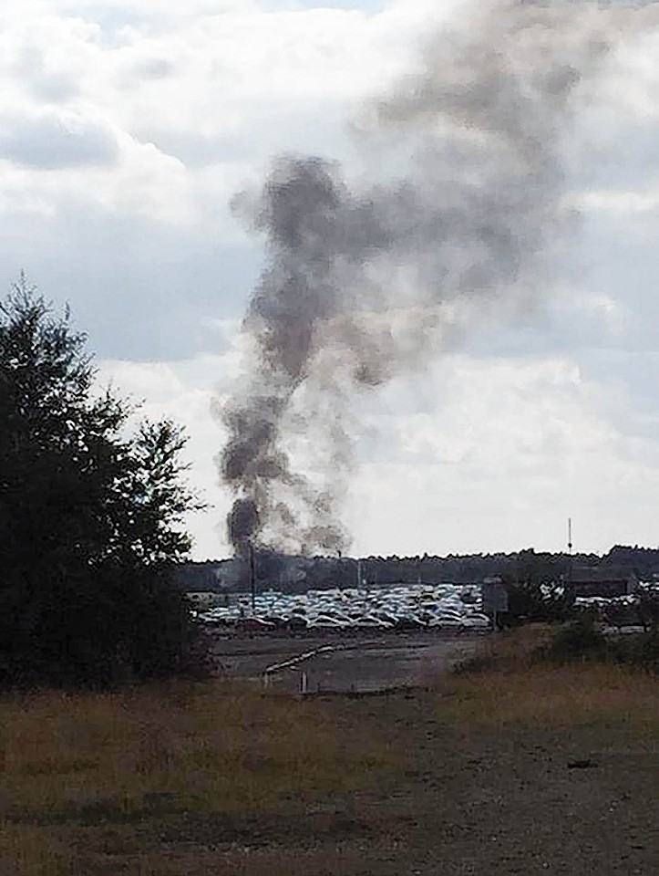 Smoke rising after a light aircraft crashed into a car auction shortly after take-off.