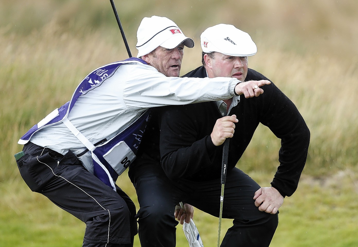 Doak takes advice from his caddy on the 16th