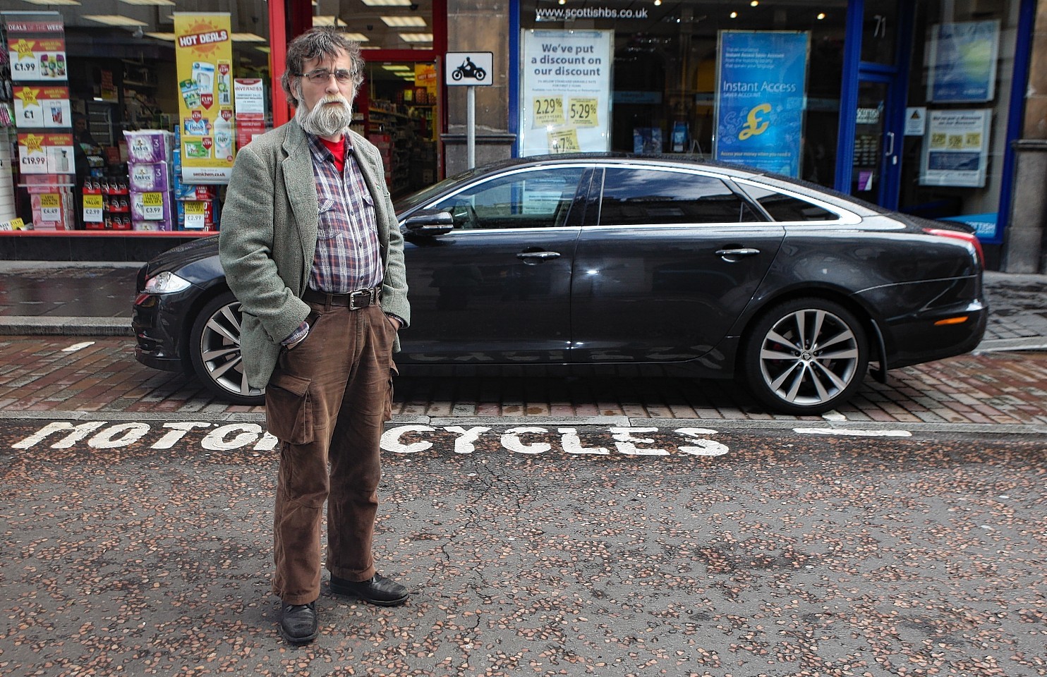 Highland Councillor Donnie Kerr with a car parked in a motor cycle bay on Queensgate, Inverness.