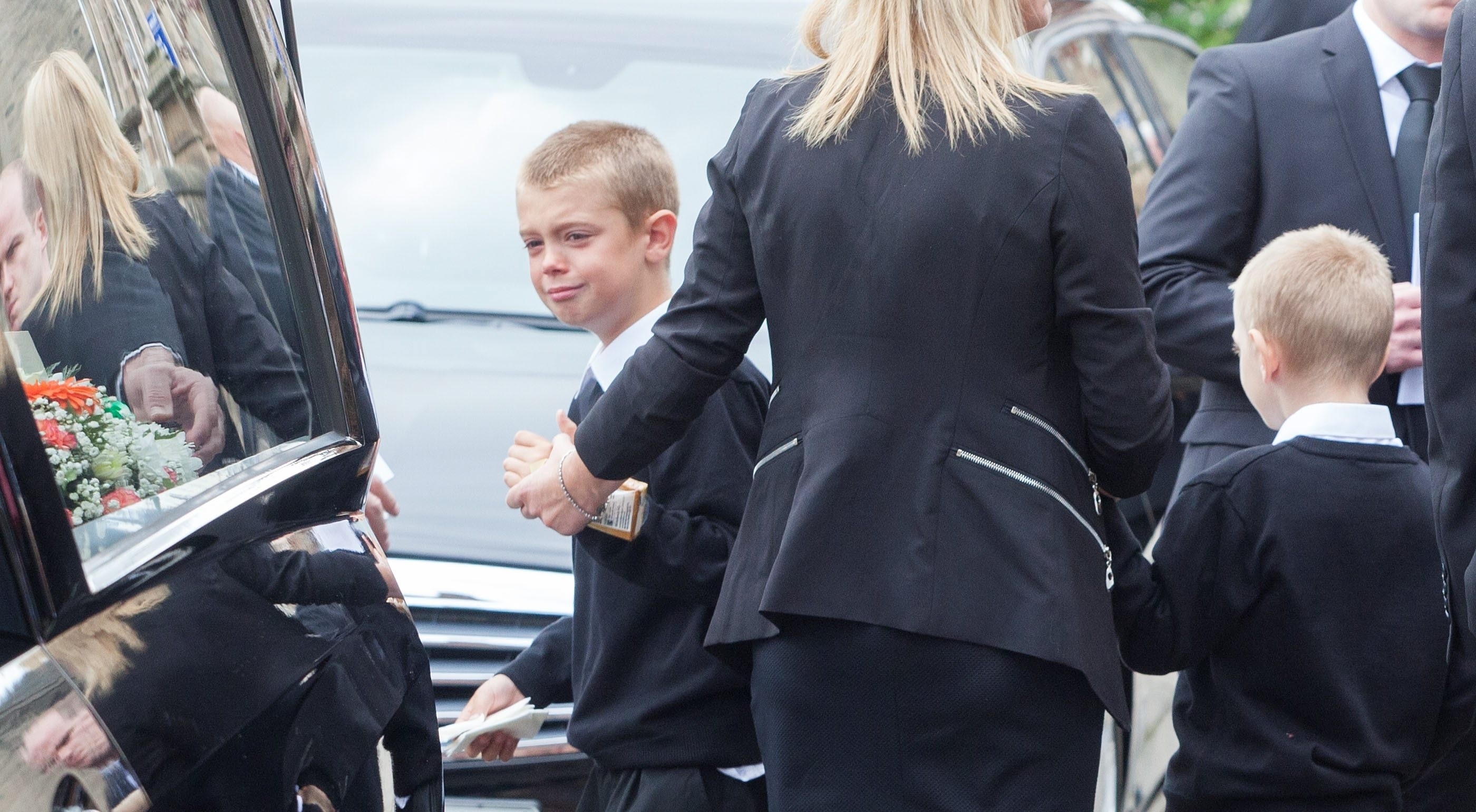 John's son after the funeral of his father. The funeral of John Yuill, 28, who died when his car crashed off the M9 and lay undiscovered for three days. His partner Lamara Bell was in the car and died later in hospital. Takes place at St Francis Xaviers Church in Falkirk. July 30 2015. See Centre Press story CPFUNERAL;
