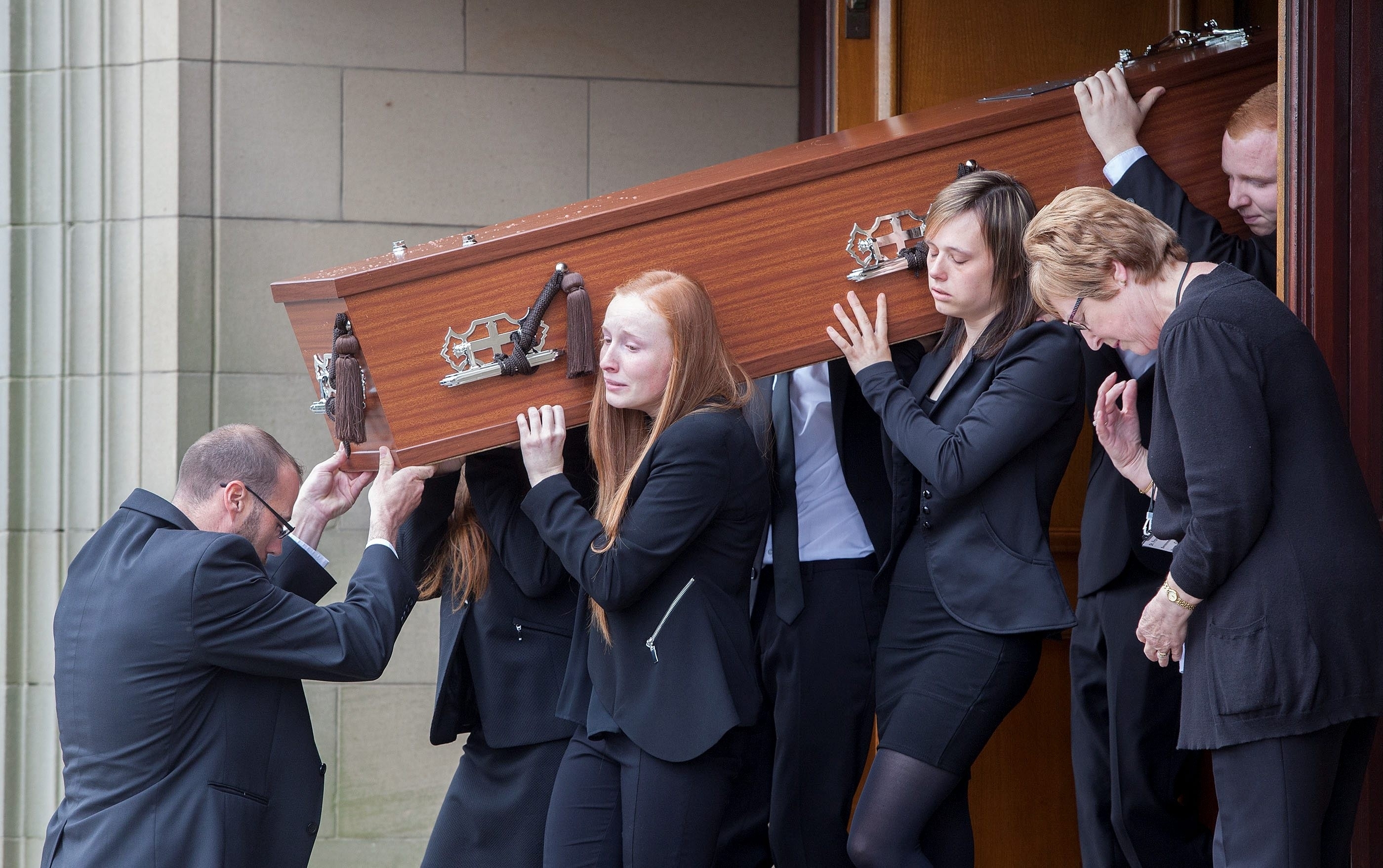 The coffin of John Yuill is carried out of the church by his brothers and sisters. The funeral of John Yuill, 28, who died when his car crashed off the M9 and lay undiscovered for three days. His partner Lamara Bell was in the car and died later in hospital. Takes place at St Francis Xaviers Church in Falkirk. July 30 2015. See Centre Press story CPFUNERAL;
