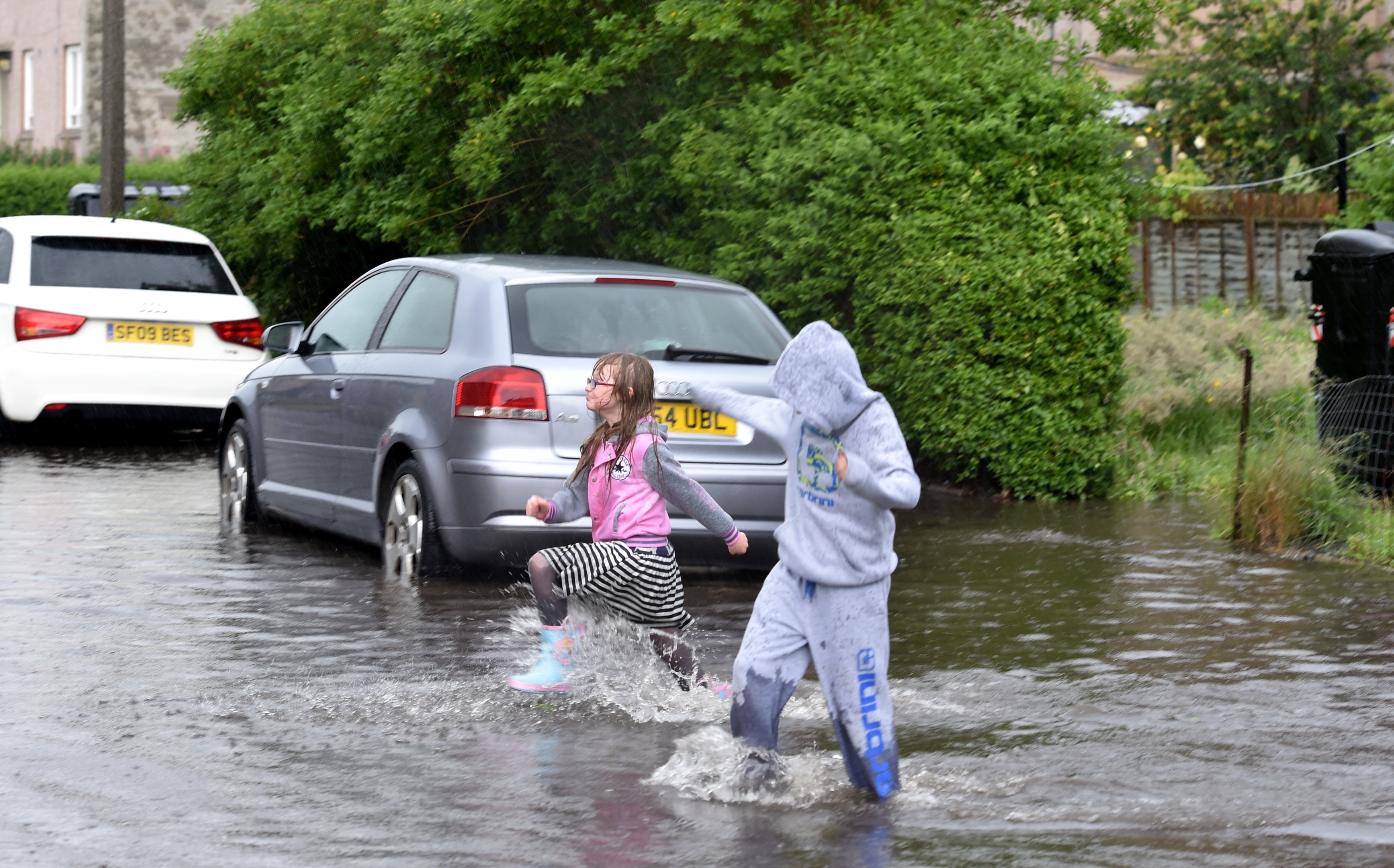 Amy Moir, 8 and Kai Neil 10 enjoy the floods at  Willowpark Crescent. Picture by Colin Rennie