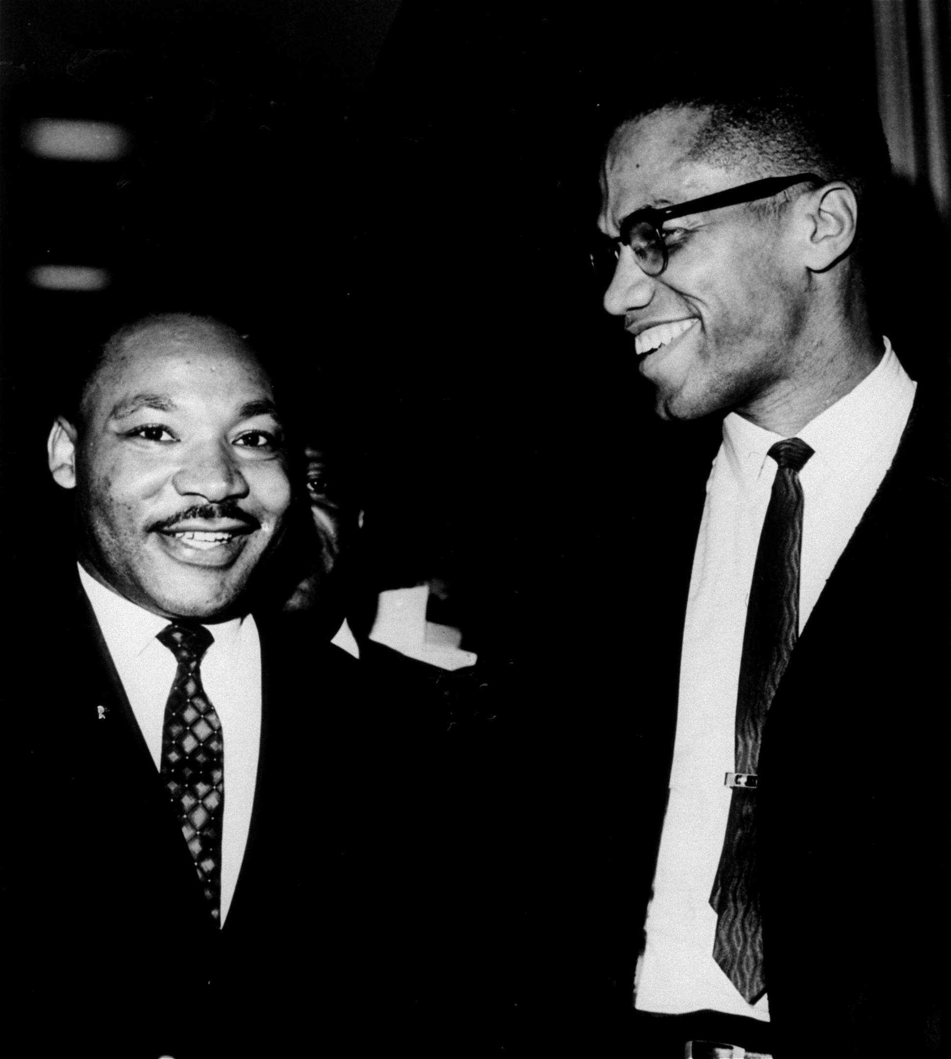 The Rev. Martin Luther King, Jr., left, and Malcolm X smile for photographers in this March 26, 1964 