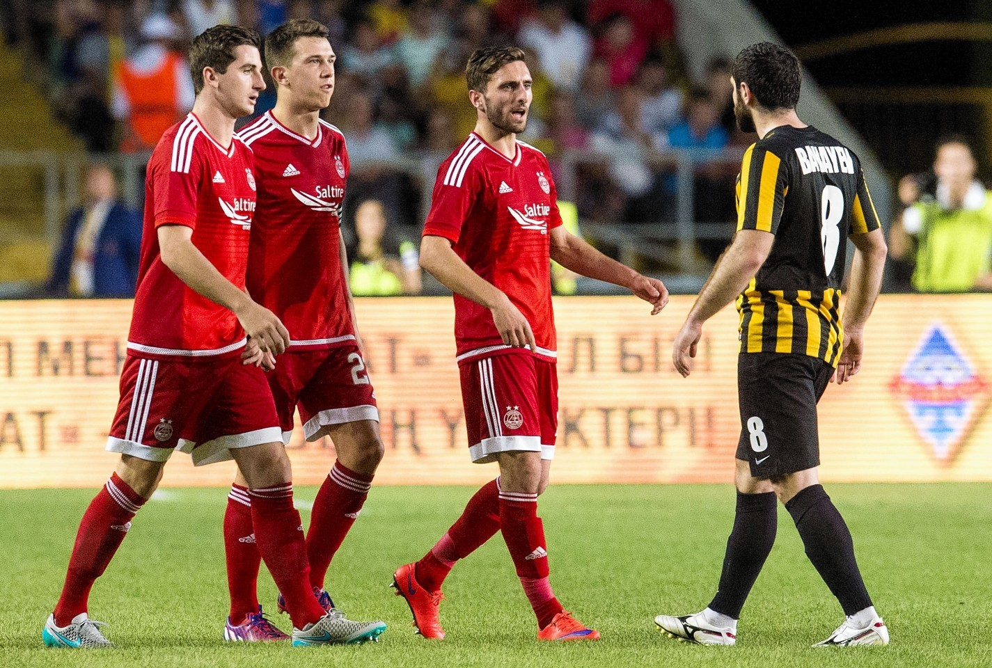 Kairat Almaty's Mikhail Bakayev exchanges words with Shinnie and his Dons team mates Ryan Jack and Kenny McLean