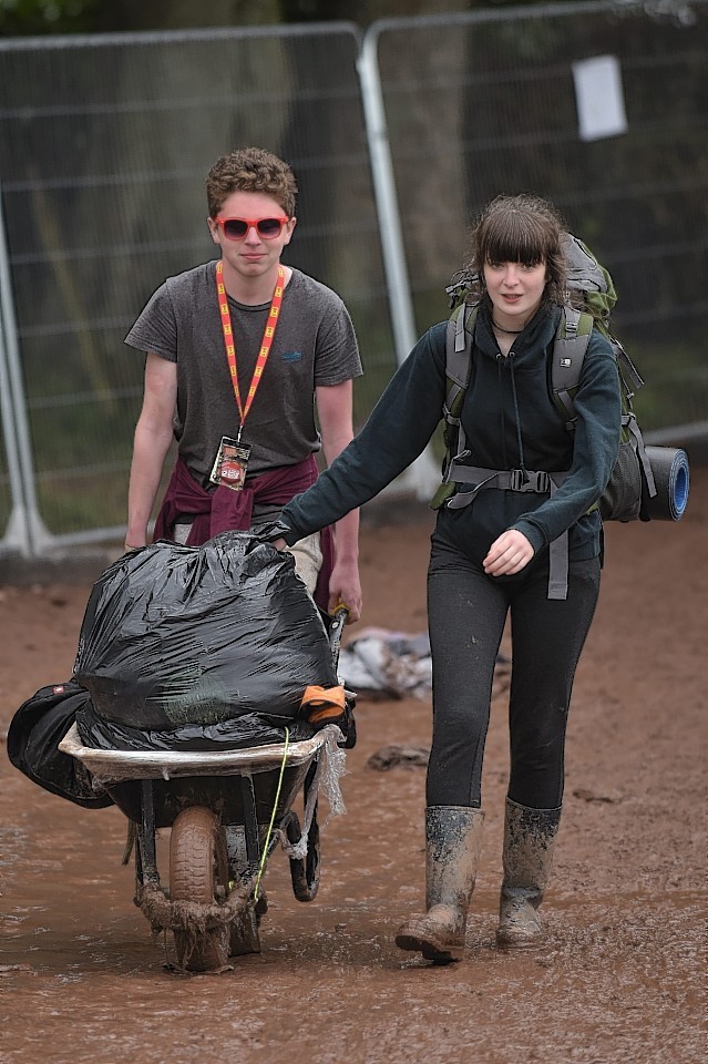 Revellers are seen waiting at a pick up zone as they wait for a lift home from T In The Park in Strathallan