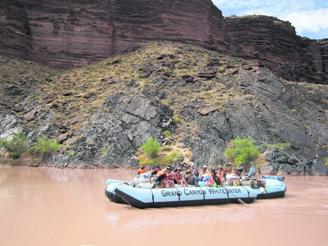 A Grand Canyon Whitewater raft cruises along on a gentle part of the Colorado River