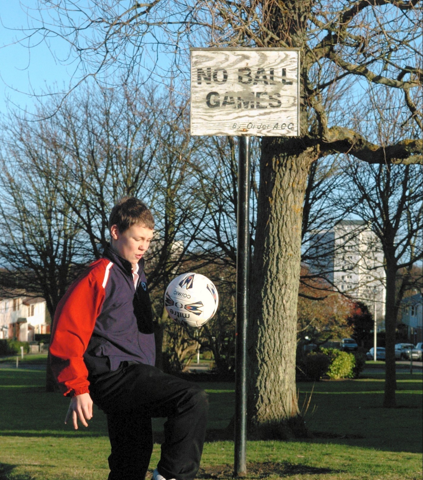 Northfield Academy pupil Kevin McAlley 14 plays football on the road close to a No Ball Games sign