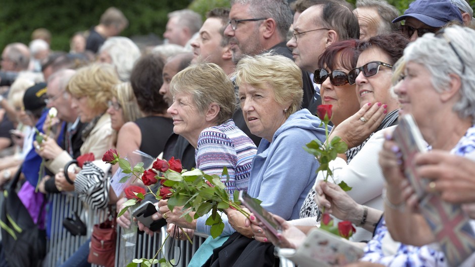 Members of the crowd wait for the start of the funeral of Cilla Black at St Mary's Church in Woolton, Liverpool
