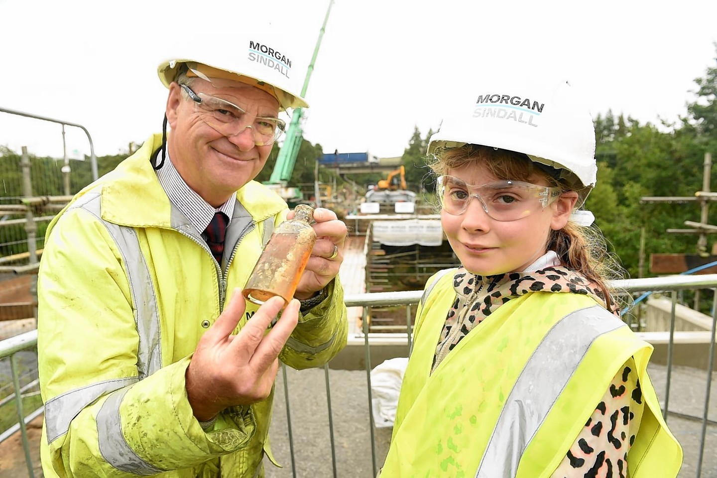 Project Manager Eric McAskill with primary seven pupil Zara MacNiven, Kingussie Primary school with the bottle of whisky removed from the time capsule.