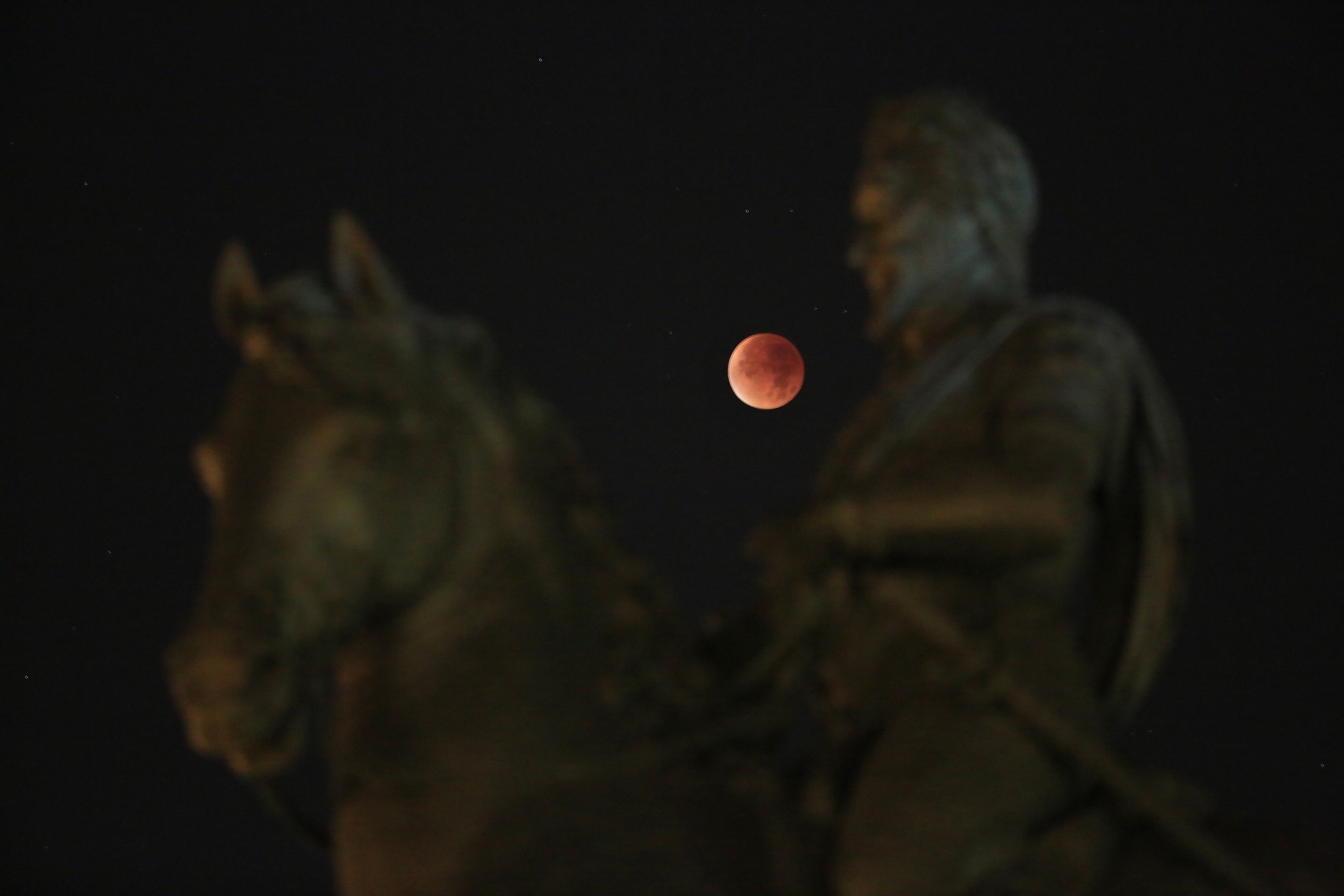 Supermoon is seen above the Statue of Henri IV, during a total lunar eclipse, in Paris, France