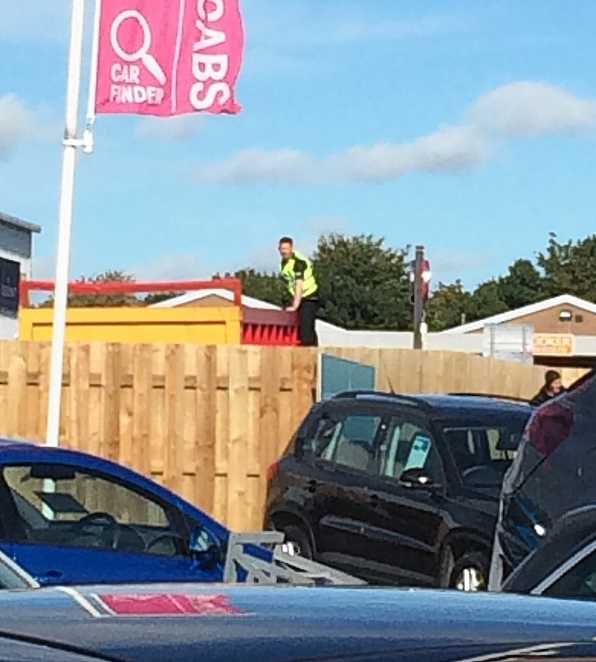 A police officer stands on a fence looking for the man 
