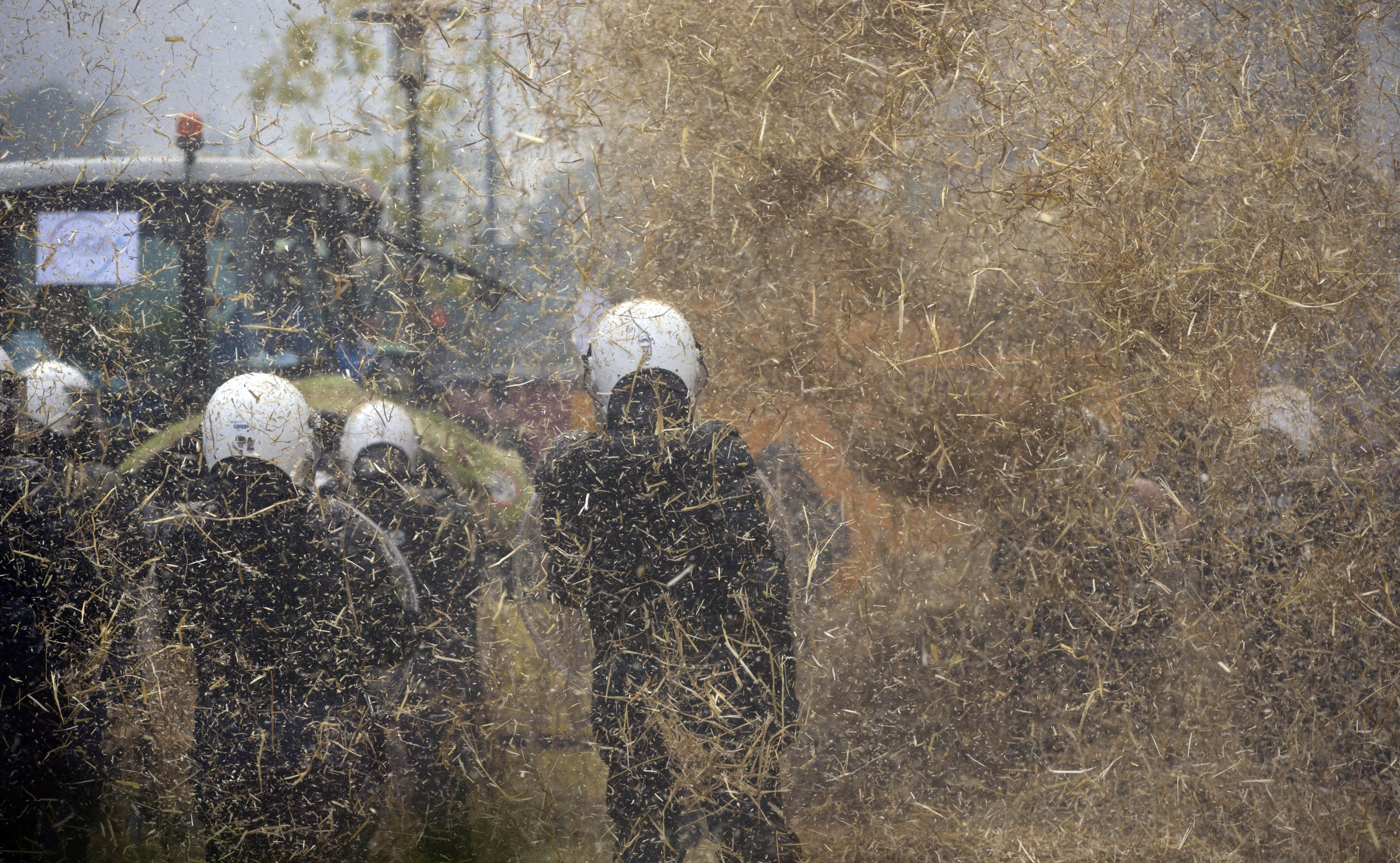 Police are sprayed with a hay machine
